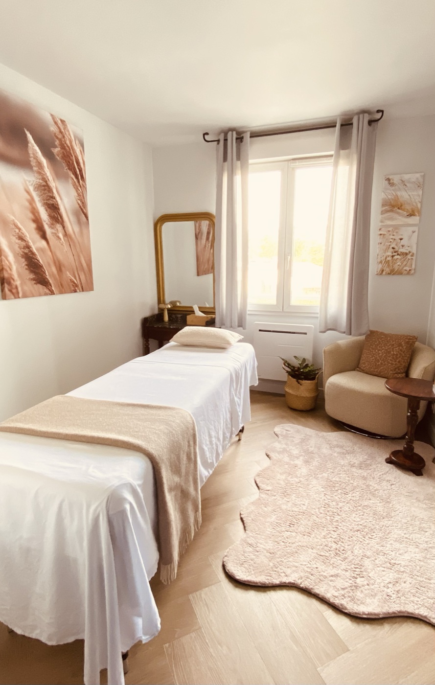 Vue d'ensemble de la salle de soin, table de massage et fauteuil